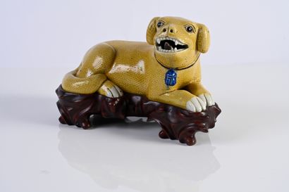 CHINE, Epoque Kangxi, XVIIIe siècle* Porcelain dog enamelled light yellow, represented...