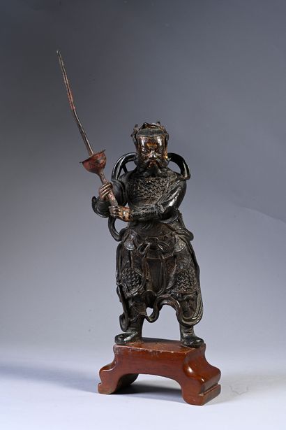 CHINE, XVIIe siècle Élégante statuette de gardien en bronze laqué, représenté debout...