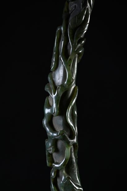CHINE, XIXe siècle Sceptre ruyi en jade épinard
Sculpté en relief dans le goût naturaliste,...