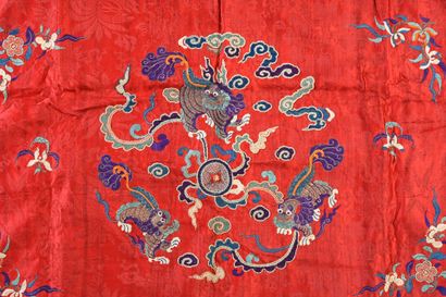 CHINE, vers 1900 Deux tentures en soie rouge à décor brodé de lions bouddhiques et...