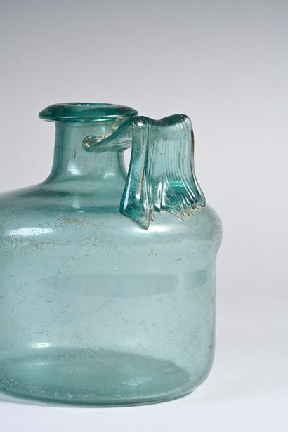 null Bottle with cylindrical body provided with a ribbon handle. Blue-green glass.
Gallo-Roman...