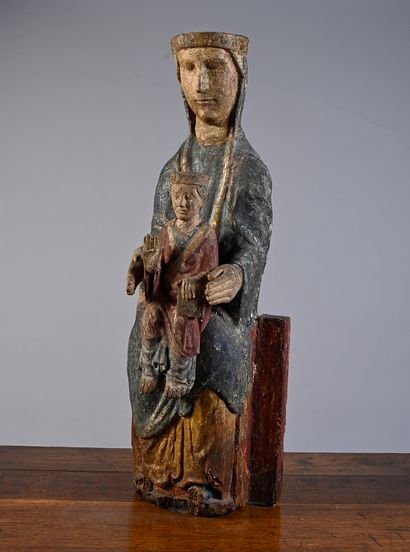 null Virgin and Child in carved and polychromed wood. Seated on a bench, Mary presents...