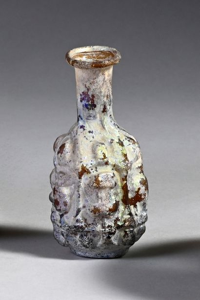 null Bottle out of moulded glass whose body is decorated in relief of a frieze of...