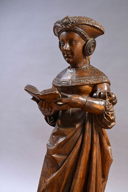 null Holy woman reading in carved walnut. Standing, holding an open book in front...