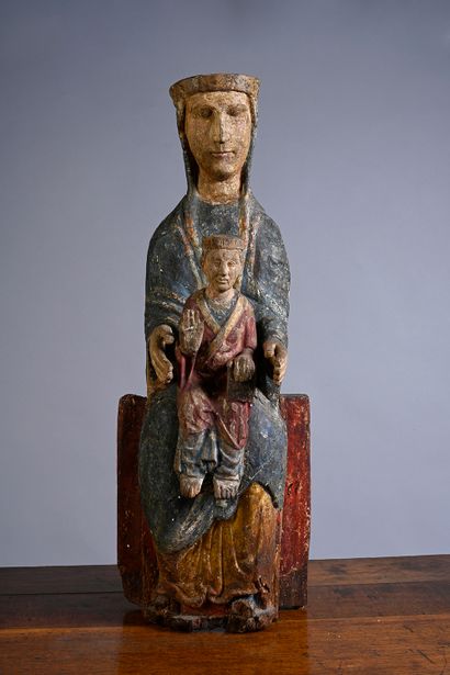 null Virgin and Child in carved and polychromed wood. Seated on a bench, Mary presents...