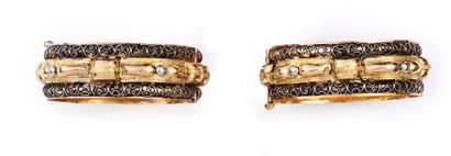 null Paire de bracelets joncs ouvrant 3 tons d'or 750e (18K), à décor géométrique...