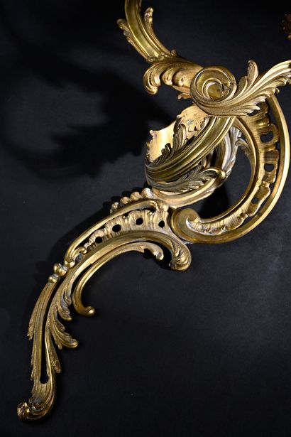 null A pair of chased and gilt bronze sconces with two rocaille scrolled lights with...