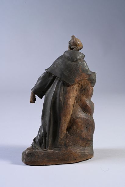 null Saint monk in polychrome terracotta. Kneeling and leaning on clouds, the religious...