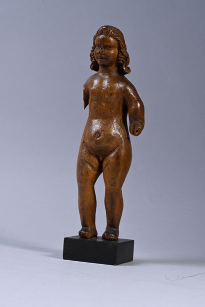 null Wooden child sculpted in the round. Standing naked, the Child has long wavy...