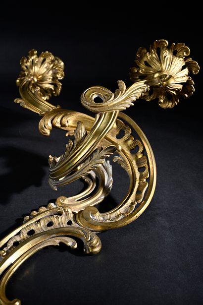 null A pair of chased and gilt bronze sconces with two rocaille scrolled lights with...