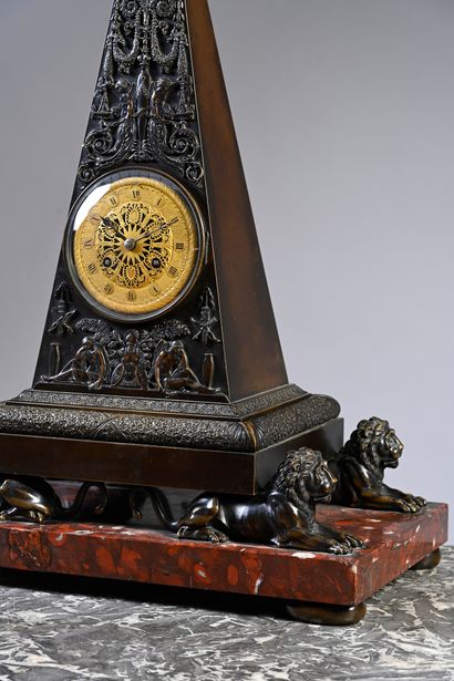 null Pyramid clock in patinated and gilded bronze resting on four lions in the antique...
