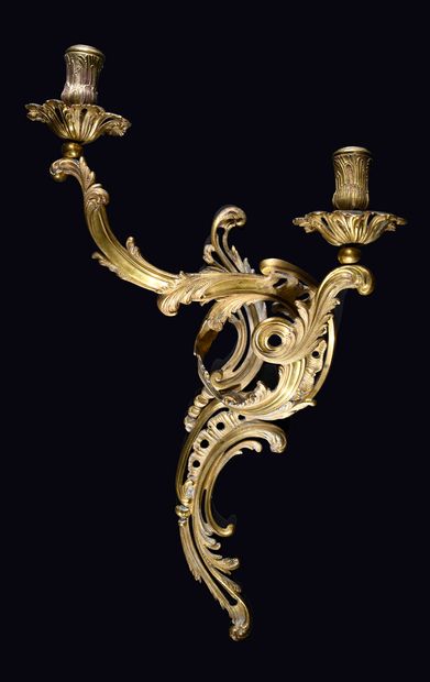 null A pair of chased and gilt bronze sconces with two rocaille scrolled lights with...