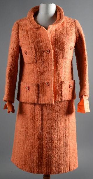 CHANEL Tailleur en tweed couleur abricot, veste courte plombée par une chaine, jupe...