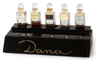 Dana (années 1950) Présentoir de magasin en plexi noir titré comprenant 5 flacons...