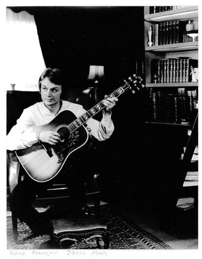 Tony Grylla Claude François avec sa guitare dans son domicile parisien. 1969. Photographie...