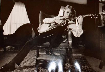 null Claude François jouant de la guitare dans son domicile parisien. Photographie...