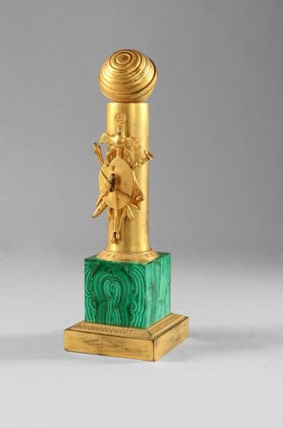 null Porte-montre en bronze doré. En forme de demi-colonne ornée d'un trophée des...