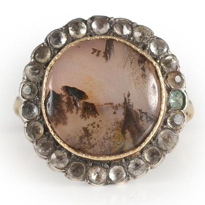 null Une bague en or et argent, de forme ronde, ornée en son centre d'une agate mousse...