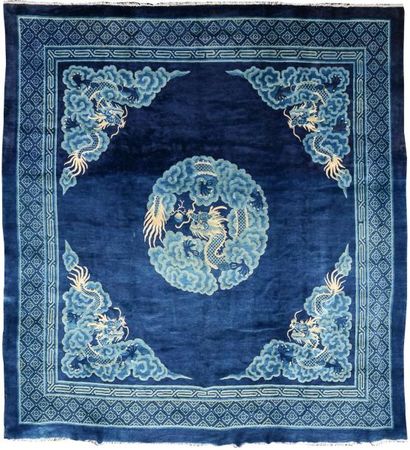 CHINE Tapis à fond bleu marine, motif central de dragon poursuivant la perle sacrée...