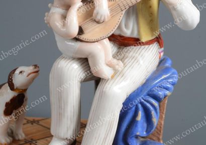 null Groupe de figurines en porcelaine polychrome, représentant un père assis à côté...