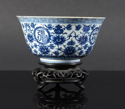 null Un bol en porcelaine à décor de fleurs de lotus et symboles auspicieux en bleu...