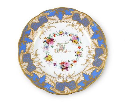 null Assiette plate en porcelaine à bords contournés. A décor polychrome d'un monogramme...