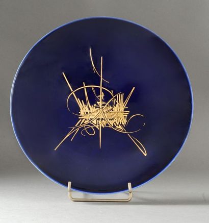 SEVRES & Georges MATHIEU Assiette en porcelaine à fond bleu à décor abstrait à l?or...
