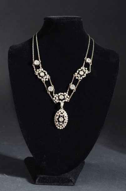 null Collier en argent, double chaînette orné au centre d'un motif ajouré serti de...