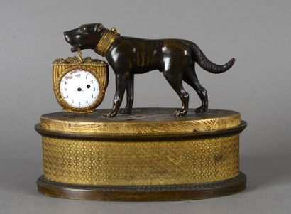 null Porte-montre en bronze patiné et doré figurant un chien tenant dans sa gueule...