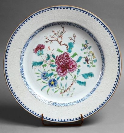 CHINE Plat rond en porcelaine à décor de la famille rose de fleurs, marli à décor...