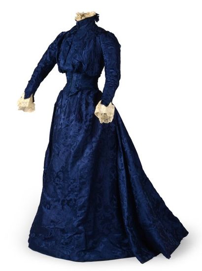 null Robe vers 1900, en damas de soie bleu à décor de rinceaux de feuillage et fleurs....