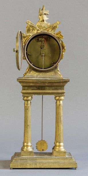 null Pendule Louis XVI, en bronze doré, à décor de trophées militaires. Cadran marqué...