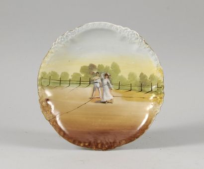 null Assiette à décor peint «Joueur et joueuse de Lawn Tennis en 1900». En porcelaine...