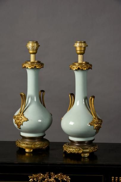 null Paire de lampes en porcelaine céladon à monture de bronze ciselé et doré chinoisante.
H.:...