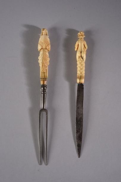  Couteau et fourchette à deux dents en fer, le manche en ivoire sculpté figurant...