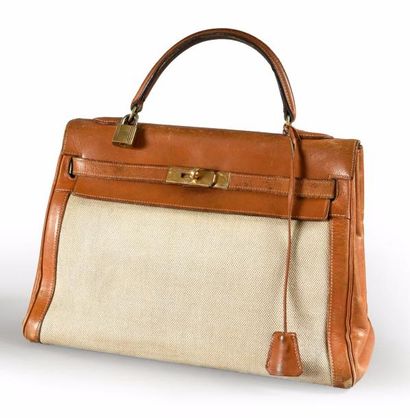 HERMES Sac KELLY, cuir naturel beige et toile «H».
Garniture en métal plaqué or,...