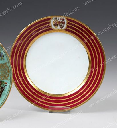 null ASSIETTE PLATE EN PORCELAINE DURE.
À décor de filets or sur fond rouge et ornée...