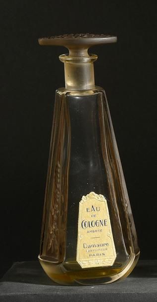 Damaure «Eau de Cologne Ambrée» (années 1920)
Elégant flacon en verre incolore pressé...