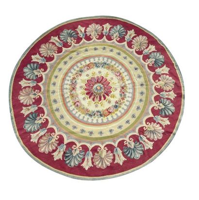 AUBUSSON Tapis en laine rond, à décor de fleurs et de palmette sur fond framboise.
D.:...