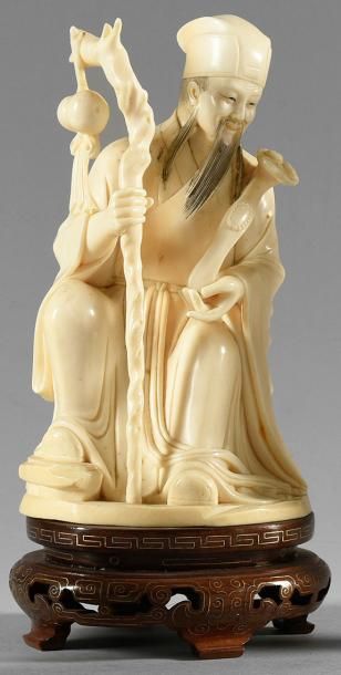 null Okimono en ivoire sculpté figurant un pèlerin assis, tenant son baton et sa...