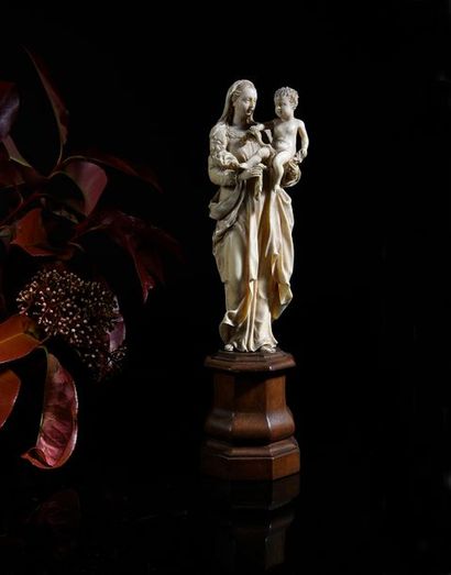 null Vierge à l'Enfant en ivoire sculpté en ronde-bosse.
Debout, Marie tient l'Enfant...