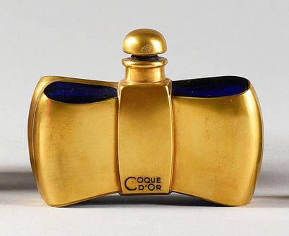 Guerlain «Coque d'Or» - (1937)
Flacon moderniste en verre pressé moulé teinté bleu...