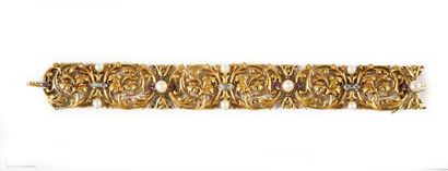  Bracelet articulé en or 750e, à motif d'enroulements feuillagés, les agrafes serties...