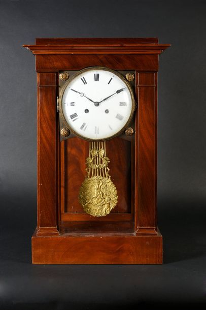 null Mahogany cage clock and carved and moulded mahogany veneer, resting on a rectangular...