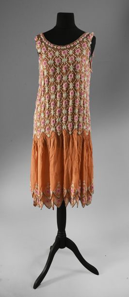 null Deux robes du soir, vers 1925, l'une sans manches en crêpe de soie abricot brodé...
