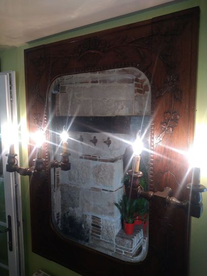 null Antique oak mirror mounted with two electrified sconces with two branches. Carved...
