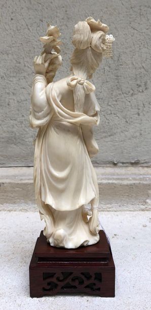 null Statuette en ivoire sculpté figurant une jeune femme debout, un bouquet de pivoines...