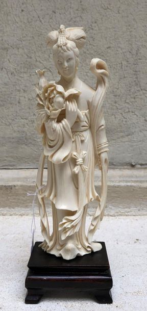null Statuette en ivoire sculpté figurant une jeune femme debout, une énorme pivoine...