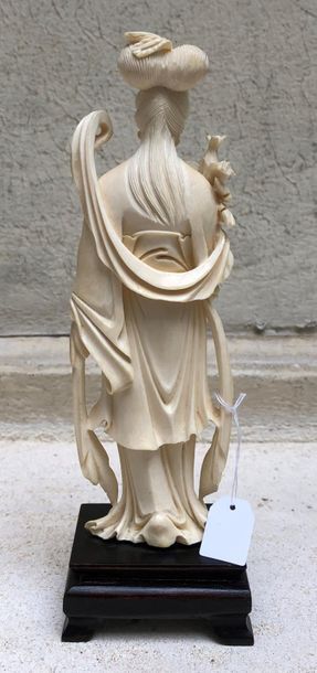 null Statuette en ivoire sculpté figurant une jeune femme debout, une énorme pivoine...