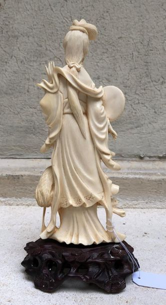null Statuette en ivoire sculpté figurant une jeune femme debout, un éventail dans...
